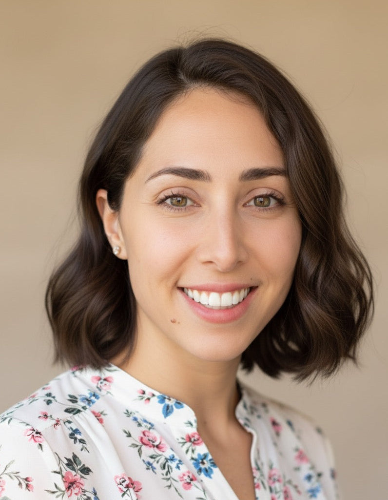 Heba, co-owner, a woman with shoulder-length brown hair wearing a floral blouse against a beige background