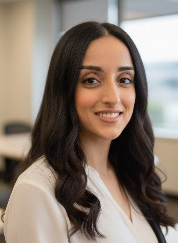 Marie, co-owner, woman with long dark hair wearing a white blouse in an office setting